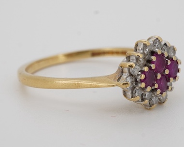 A ruby and diamond ring, designed as a lozenge-shaped cluster, set with four circular-cut rubies within a border of circular-cut diamonds, mounted in 18ct gold, size O, British hallmarks, gross weight 3 grams, Condition: